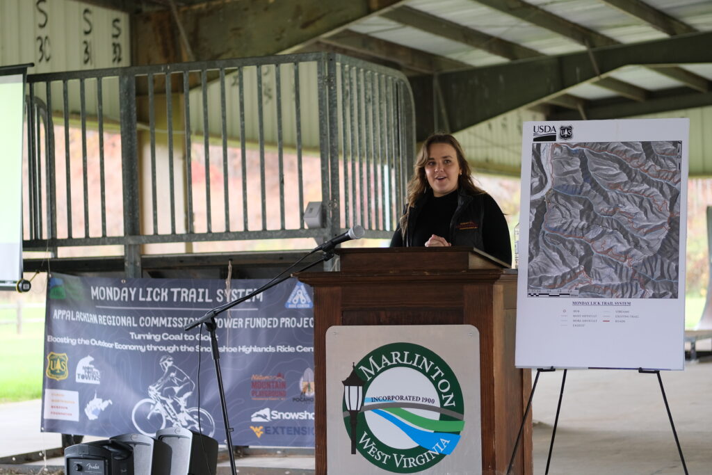 Pocahontas County CVB Director Chelsea Faulkiner at Podium Speaking about Monday Lick
