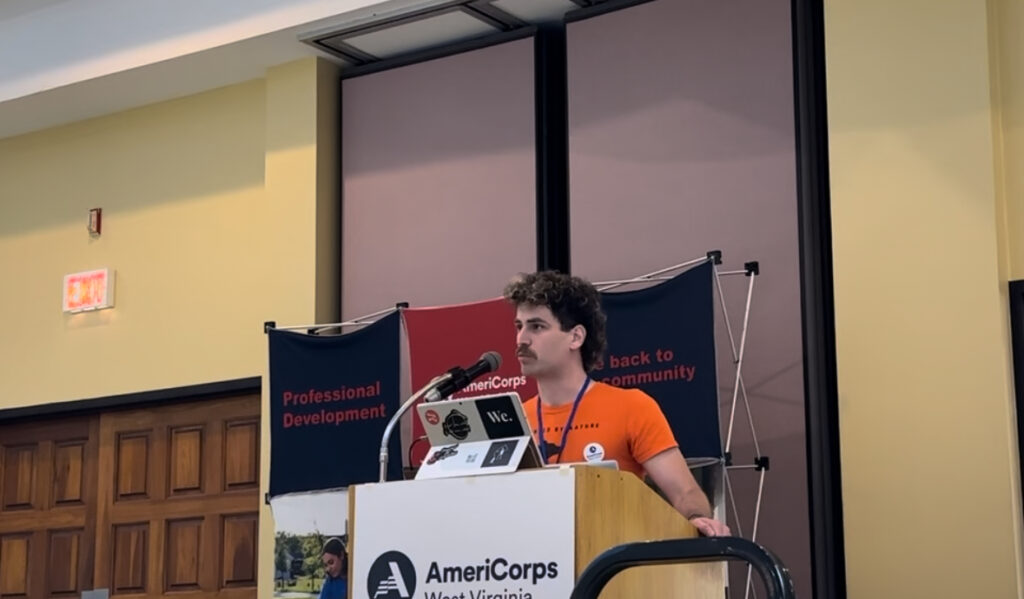 Mon Forest Towns AmeriCorps Sam Kniery speaks at podium during the Volunteer WV Award Ceremony